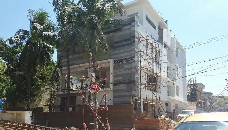 The villa under construction, with scaffolding against the stone-clad facade