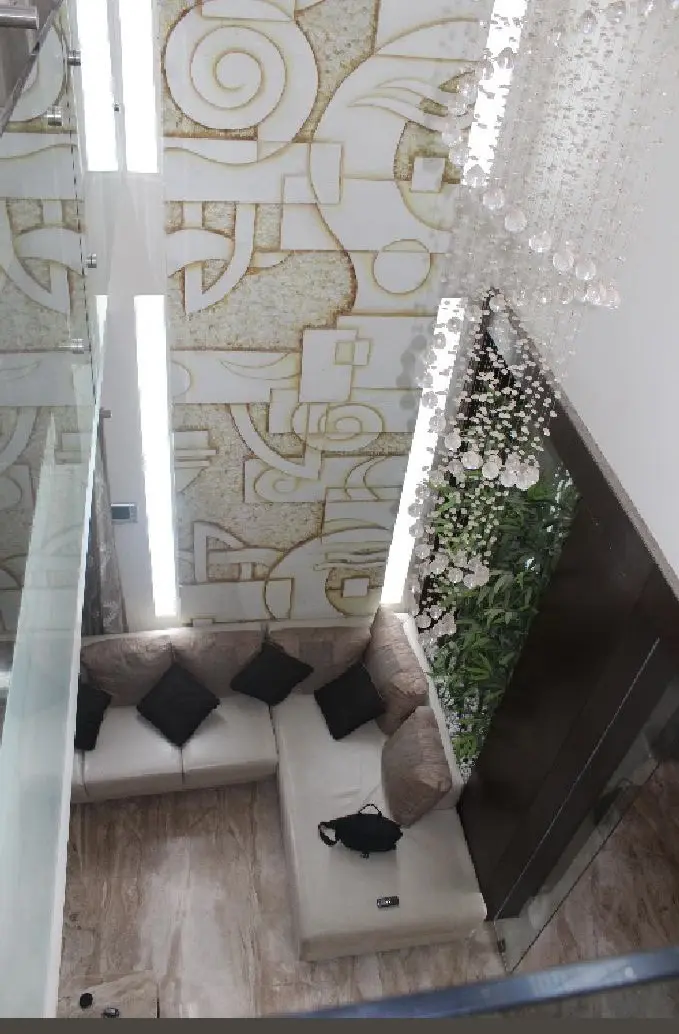 Living room seen from above, with the carved stone wall and a slim vertical light