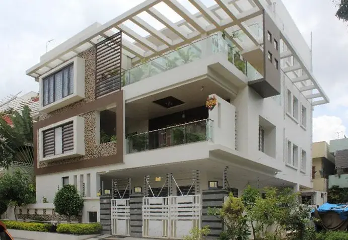 Three-storey villa with timber and stone accents, white balconies and a pergola on the terrace