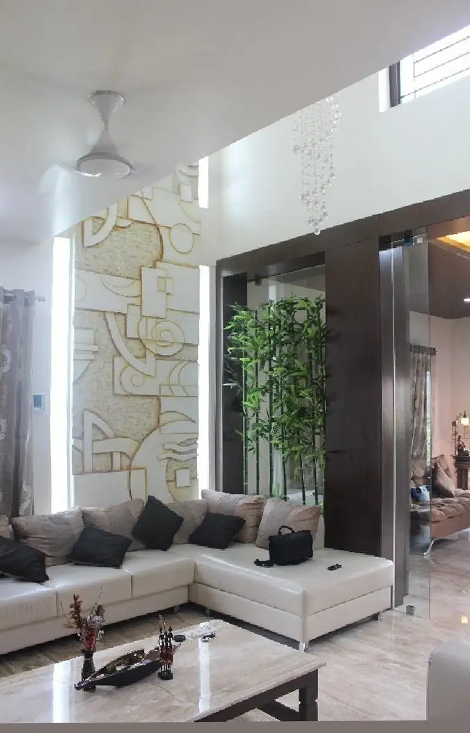 Living room with a white sectional sofa and a carved stone feature wall