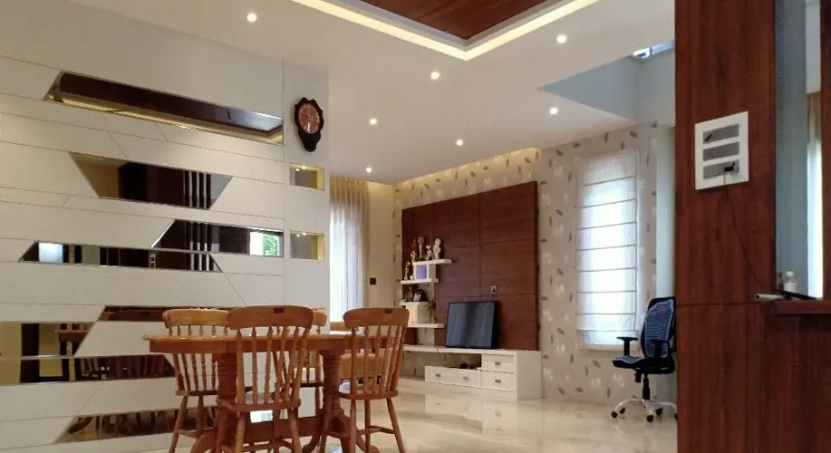Dining area with mirrored strip panelling and a timber crockery unit