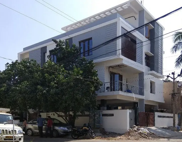Three-storey duplex on a corner plot, grey and white with timber-slatted balconies