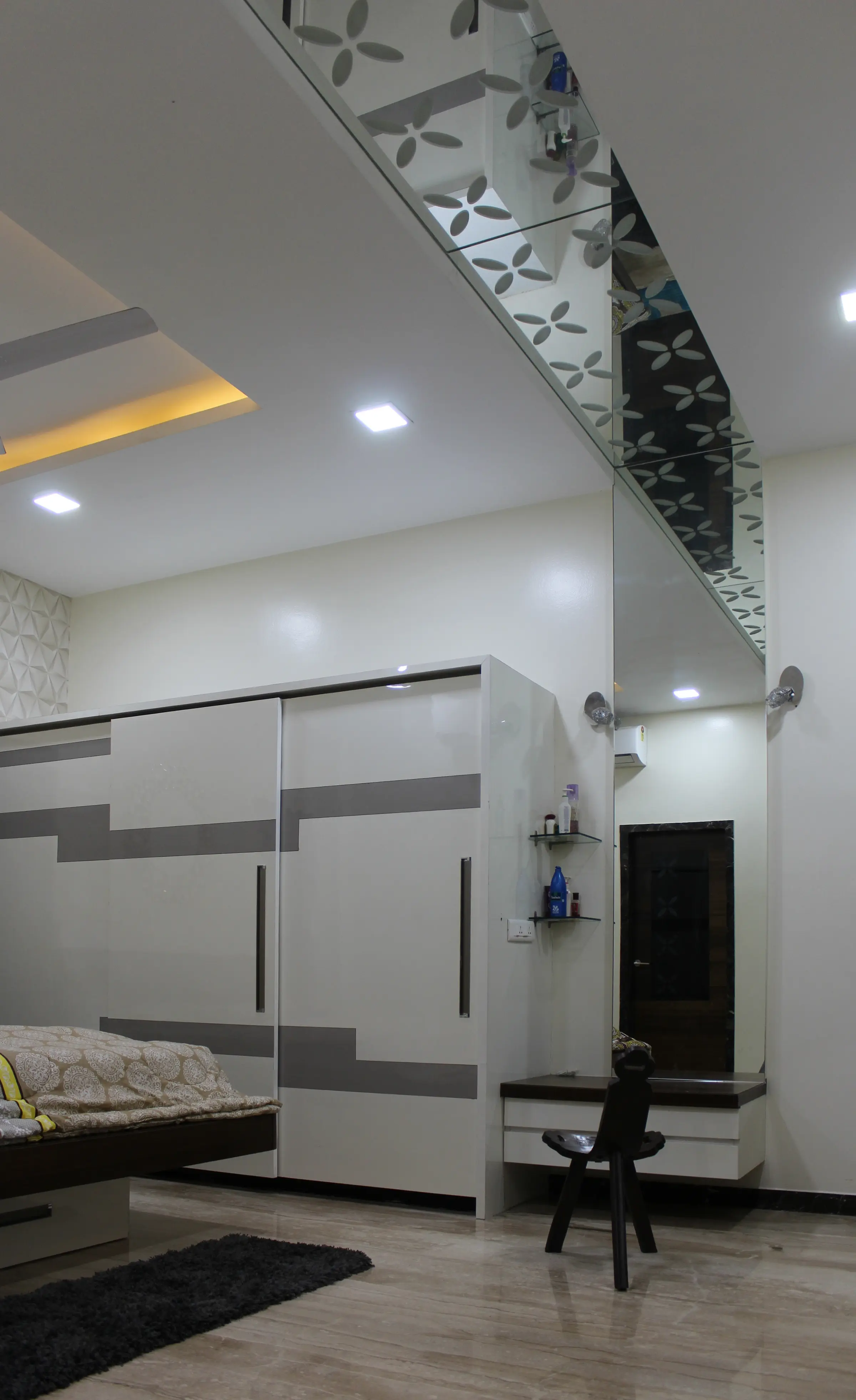 Bedroom with a grey and white wardrobe wall and a laser-cut screen overhead