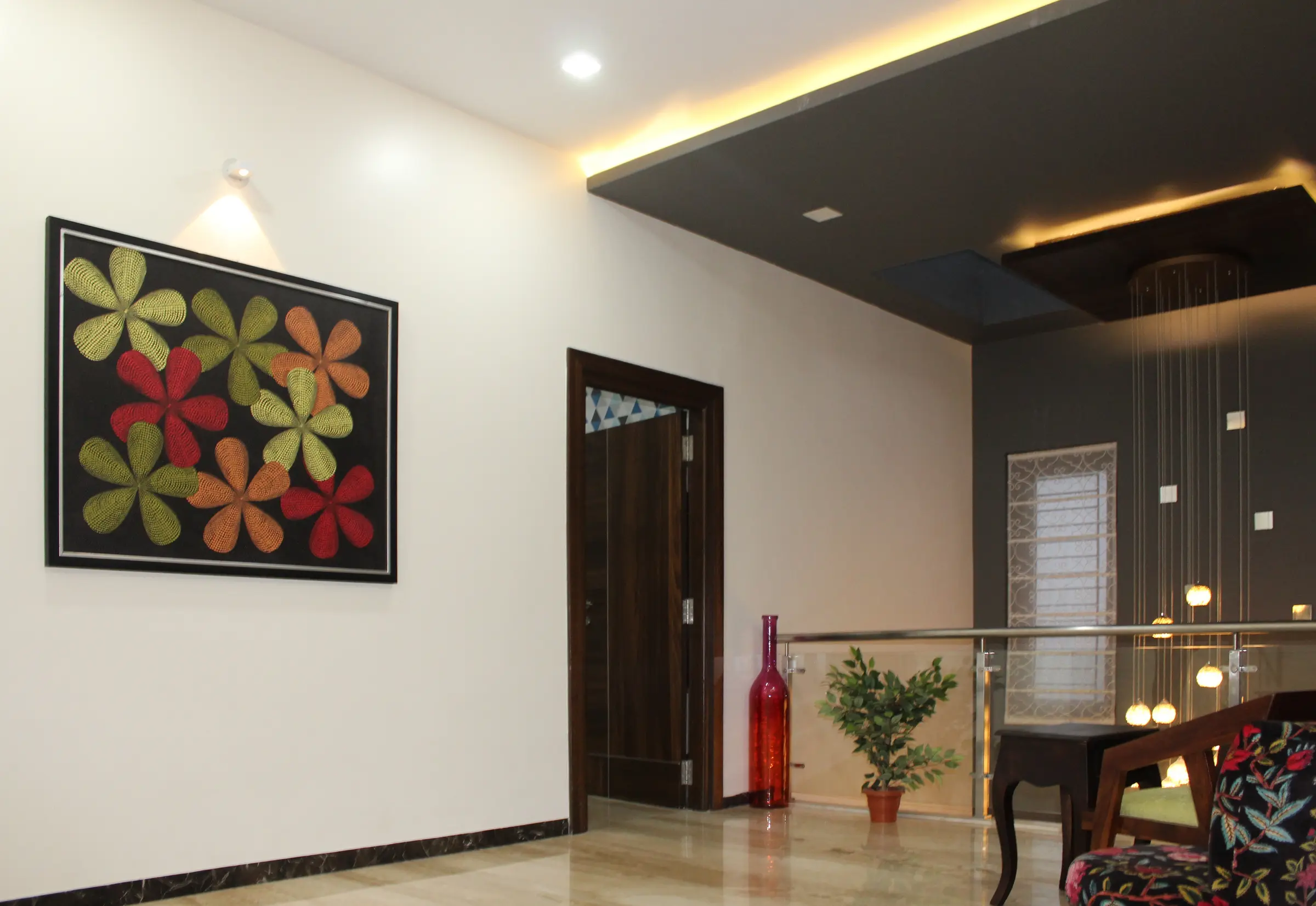 Entrance lobby with a framed floral painting, a dark timber door and a lowered ceiling with cove lighting