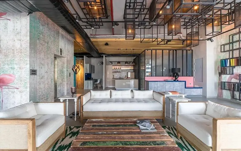 Showroom lounge with white sofas around a reclaimed-timber table