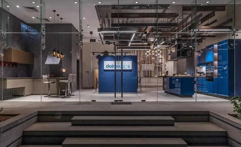 Showroom entrance seen through glass, with steps down to the display floor