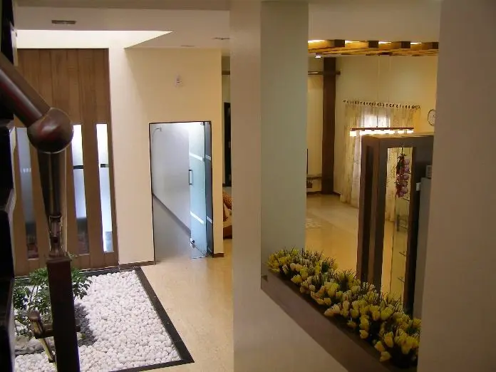Corridor past an internal pebble garden lined with yellow flowers