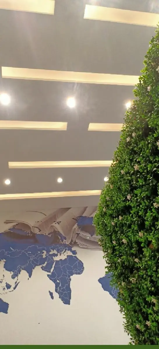 Linear ceiling lights above a planted column and the world map mural