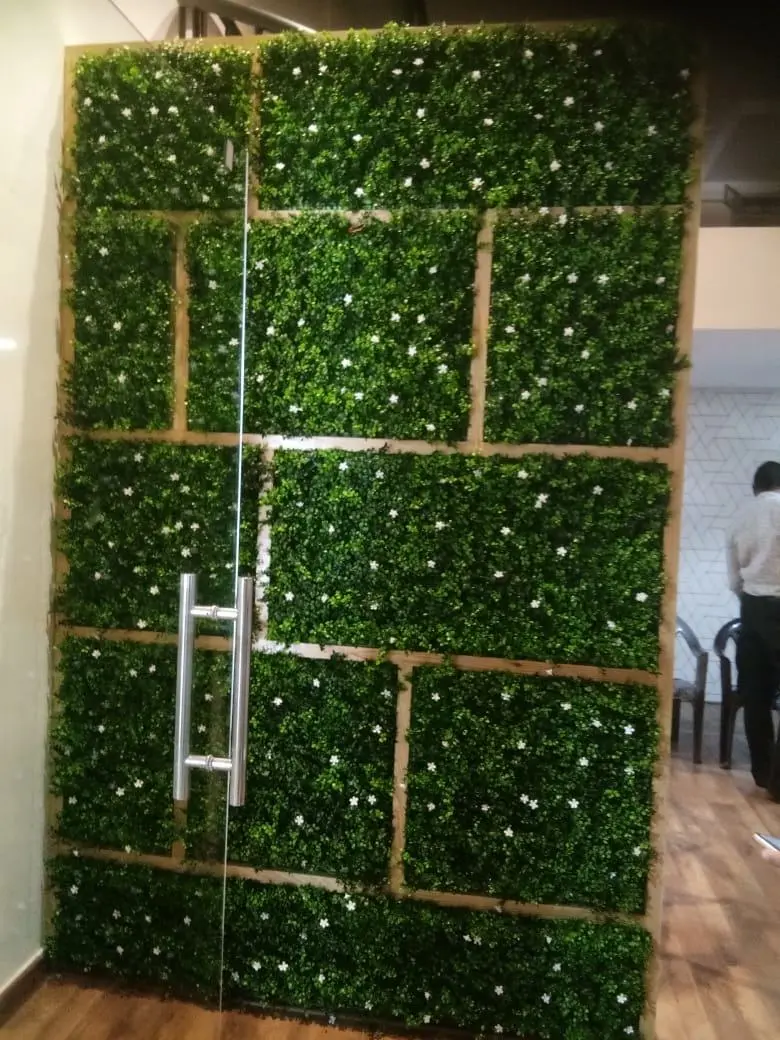 Wall of moss panels with a long steel door handle