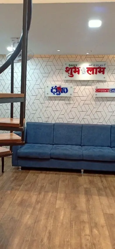 Waiting area with a blue sofa and the agency's sign on a patterned wall