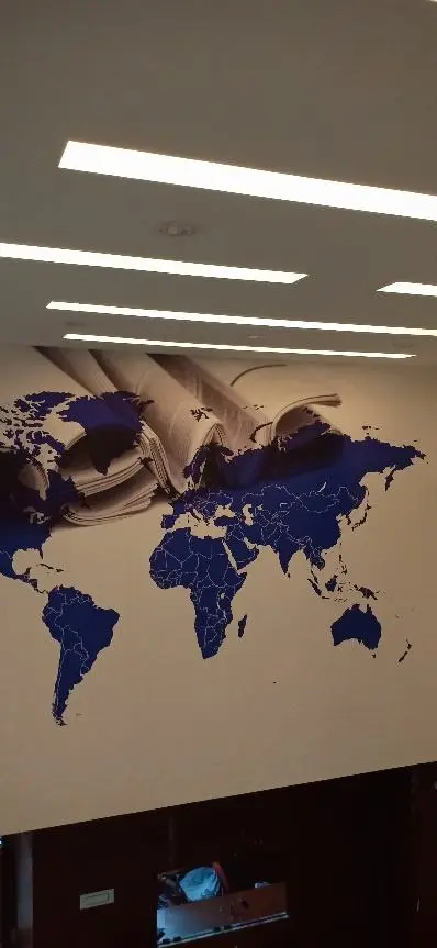 Reception wall with a navy world map and linear ceiling lights