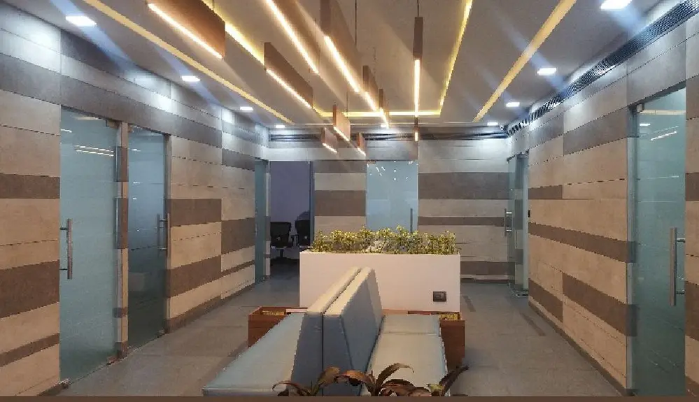 Office corridor with striped stone-tile walls, glass doors and gold linear lights