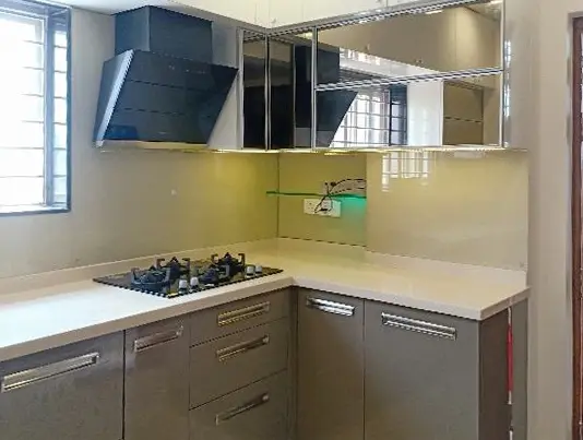 Kitchen with a black glass chimney, a yellow backsplash and grey cabinets