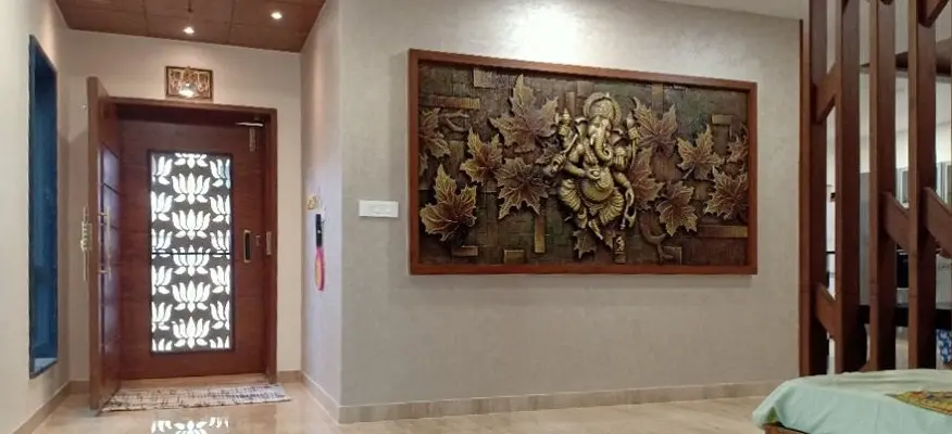 Foyer with a large relief artwork of Ganesha and a carved main door