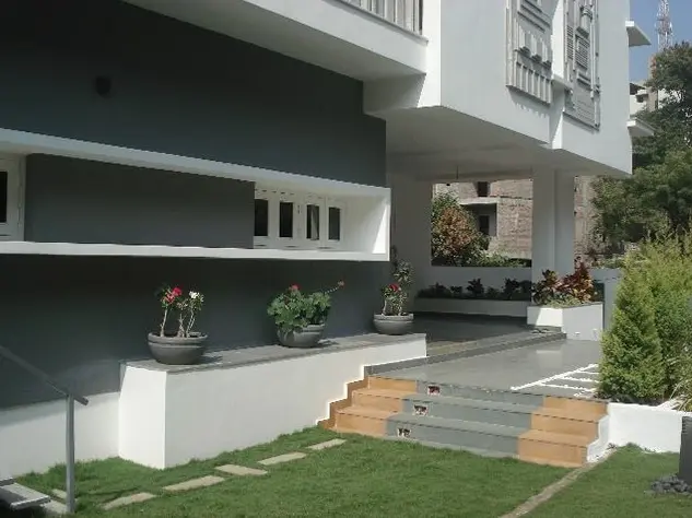 Garden steps with timber-edged treads leading up to a grey and white house