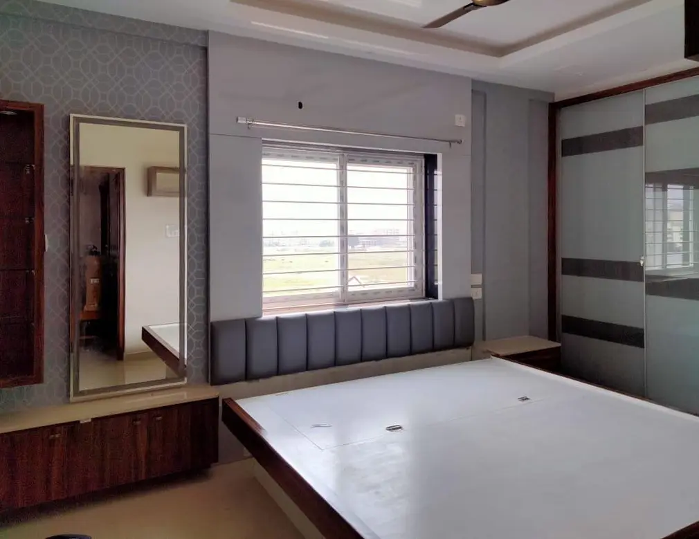 Bedroom with a slatted headboard, a full-height mirror and a sliding wardrobe