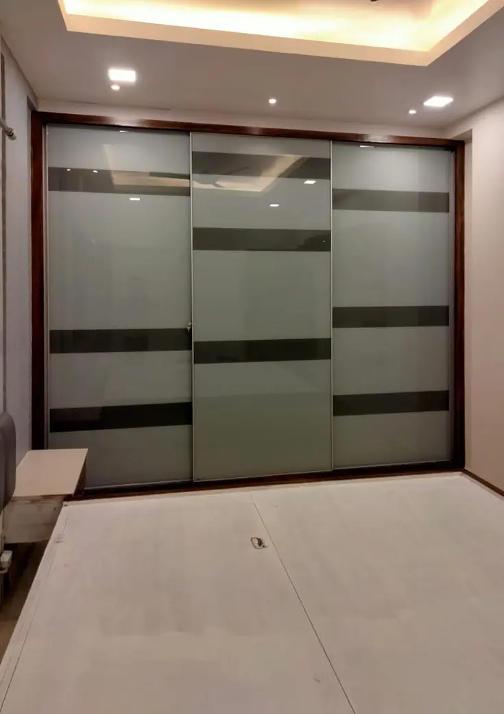 Sliding wardrobe in frosted glass with dark timber bands