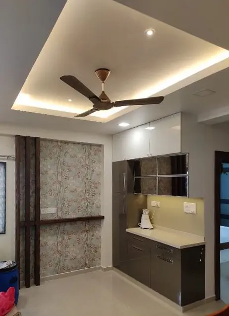 Crockery unit with a lit glass shelf beside a textured wallpaper column
