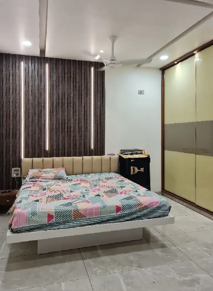 Bedroom with a quilted headboard, a slatted timber panel and a sliding wardrobe