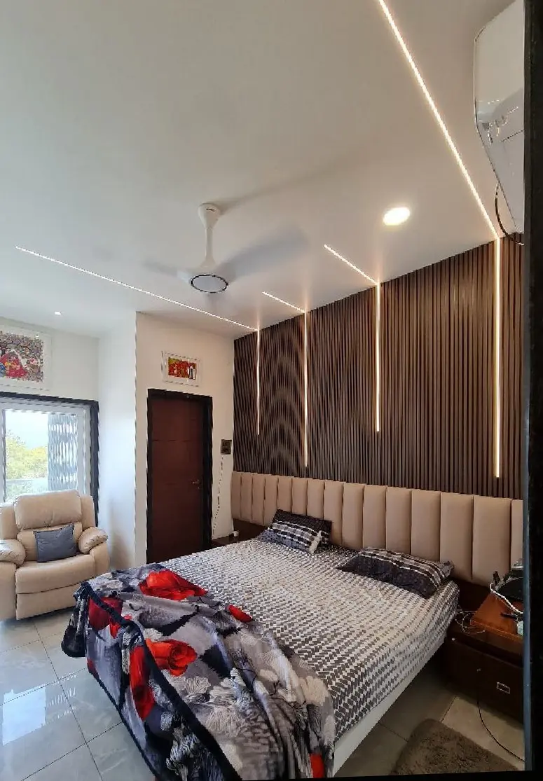 Bedroom with a tall timber headboard wall and cove lighting